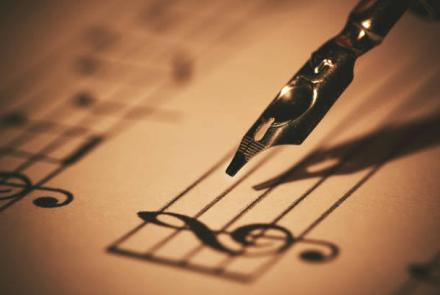 An image of a music sheet and quill pen 